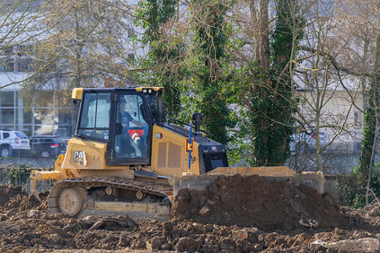 CAT bulldozer with blade doing site preparation work