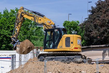 Yellow excavator performing site preparation and excavation work